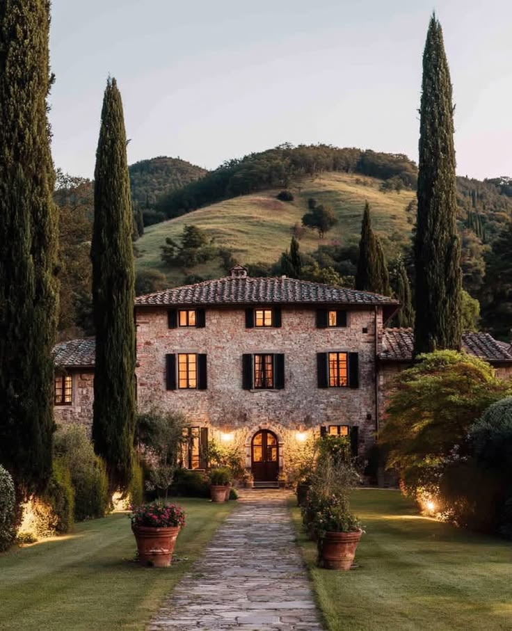 Villa in pietra tra i cipressi al tramonto